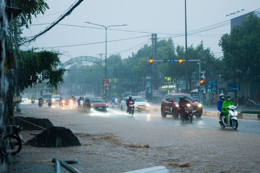 Nước ngập hết nửa mặt đường khiến xe máy phải chen chúc sang làn đường ô tô để di chuyển. Ảnh: Huy Tịnh Nước ngập hết nửa mặt đường khiến xe máy phải chen chúc sang làn đường ô tô để di chuyển. Ảnh: Huy Tịnh