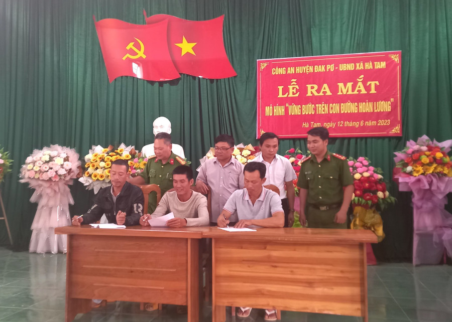 Đại diện công an xã, chính quyền địa phương và các công dân chấp hành xong án phạt tù đã ký cam kết thực hiện quy chế mô hình. Ảnh: Tuyết Mai