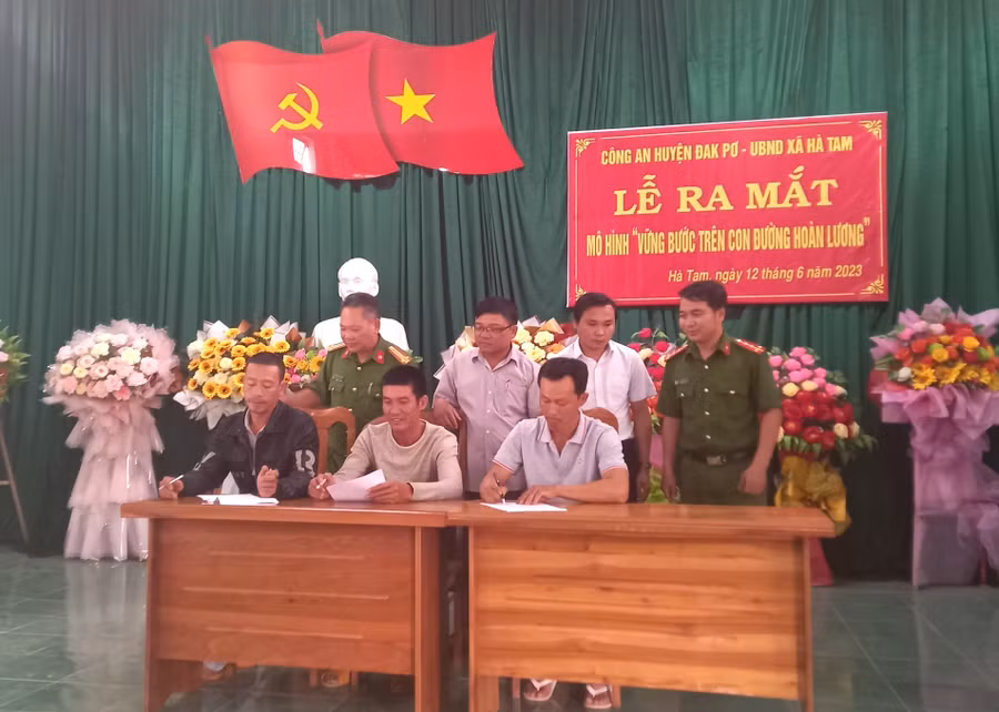 Đại diện công an xã, chính quyền địa phương và các công dân chấp hành xong án phạt tù đã ký cam kết thực hiện quy chế mô hình. Ảnh: Tuyết Mai