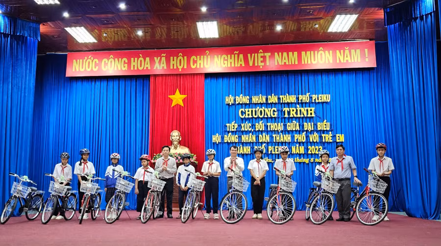 Lãnh đạo HĐND thành phố tặng 10 chiếc xe đạp cho 10 em học sinh vượt khó học giỏi. Ảnh: Bá Bính