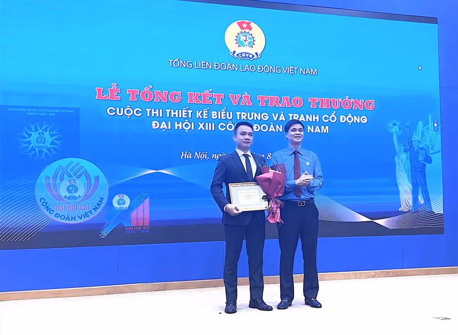 Phó Chủ tịch Tổng LĐLĐVN Ngọ Duy Hiểu (bên phải) trao Giải Nhất thiết kế biểu trưng cho tác giả Nguyễn Ngọc Huy Mẫn. Ảnh: Hà Anh/Báo Lao Động