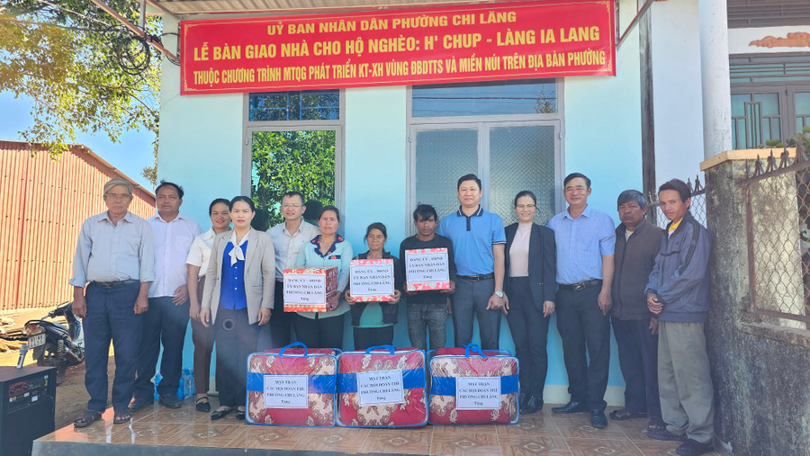 Đại diện lãnh đạo chính quyền địa phương cùng nhà hảo tâm trao nhà và quà cho các hộ gia đình. Ảnh: Bá Bính