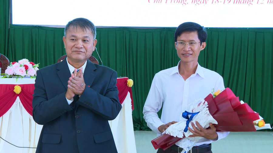 Bí thư Huyện ủy, Chủ tịch HĐND huyện Đinh Văn Dũng (bìa trái) tặng hoa ông Trần Quyết Thắng-Ủy viên UBND huyện, nhiệm kỳ 2021-2026, Trưởng phòng Văn hóa-Thông tin huyện. Ảnh: Khánh Linh