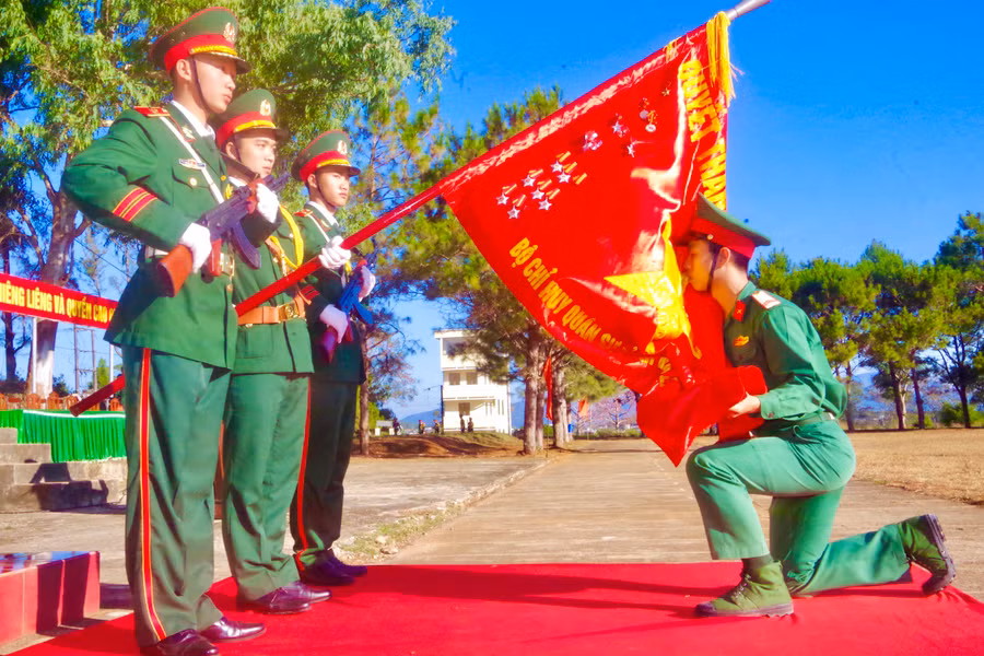 Chiến sĩ hôn Quân kỳ Quyết thắng tại lễ tiễn hạ sĩ quan, chiến sĩ năm 2024. Ảnh: Kim Hồng