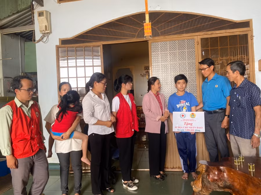 Đoàn công tác tặng quà và trao tiền mặt cho em Phạm Ngọc Toàn. Ảnh: Hồng Ngọc