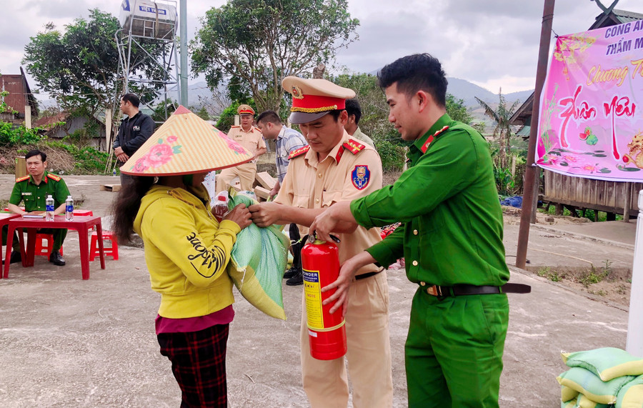 Các chiến sĩ Công an trao quà cho bà con. Ảnh: Lan Anh