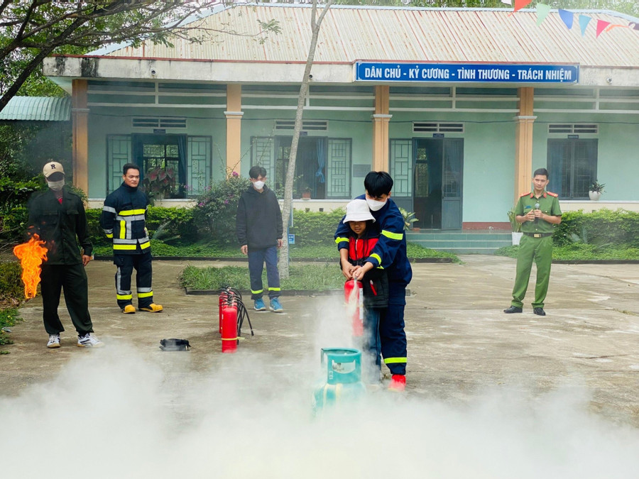 Các chiến sĩ Đội Chữa cháy-Cứu nạn cứu hộ hướng dẫn các em học sinh sử dụng bình chữa cháy. Ảnh: Lan Anh