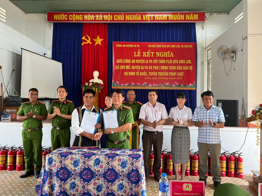 Lãnh đạo Công an huyện Ia Pa và đại diện hệ thống chính trị thôn Plơi Apa Ama Lim (xã Chư Mố) ký kết bản giao ước kết nghĩa. Ảnh: Mai Linh