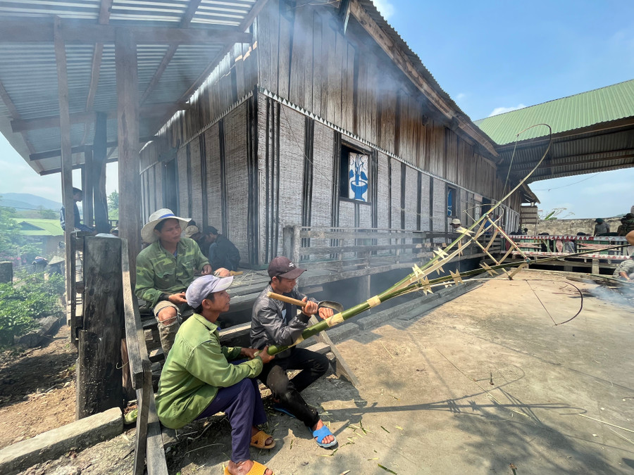 Thanh niên cùng người già cùng chuẩn bị cây nêu cho lễ cúng. Ảnh: Phương Linh