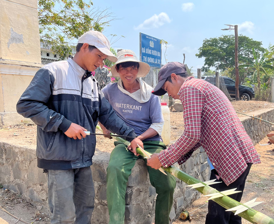 Thanh niên làng Prăng trang trí cho cây nêu. Ảnh: Phương Linh