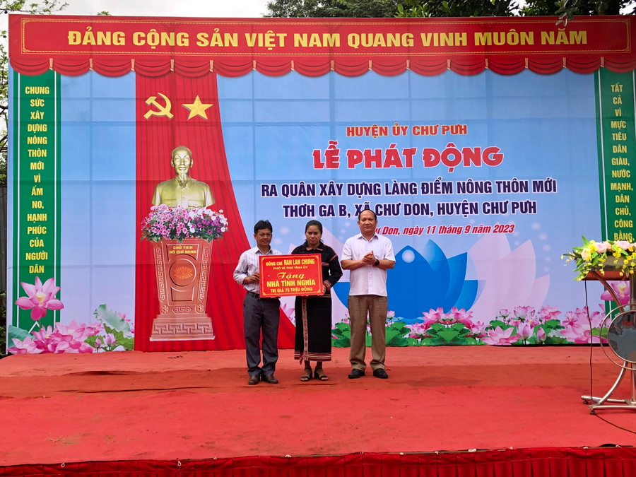 Phó Bí thư Tỉnh ủy Rah Lan Chung (bìa phải) tặng 1 căn nhà tình nghĩa cho hộ nghèo ở làng Thơ Ga B trị giá 70 triệu đồng. Ảnh: Lê Nam