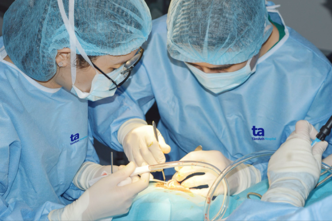 Bác sĩ Hương (trái) lấy mảnh vá màng nhĩ trong phẫu thuật vá nhĩ nội soi cho một người bệnh. Ảnh minh họa: Bệnh viện Tâm Anh