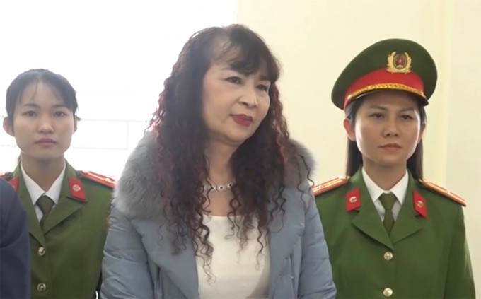 Nghi can Nguyễn Thị Kim Tiến (giữa) nghe cảnh sát đọc lệnh bắt. Ảnh: Công an cung cấp