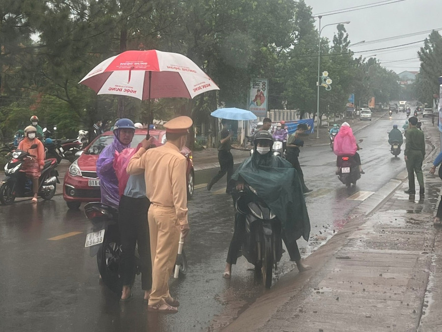 Lực lượng Công an huyện Đức Cơ che dù cho các thí sinh vào điểm thi khi thời tiết trên địa bàn huyện có mưa lớn