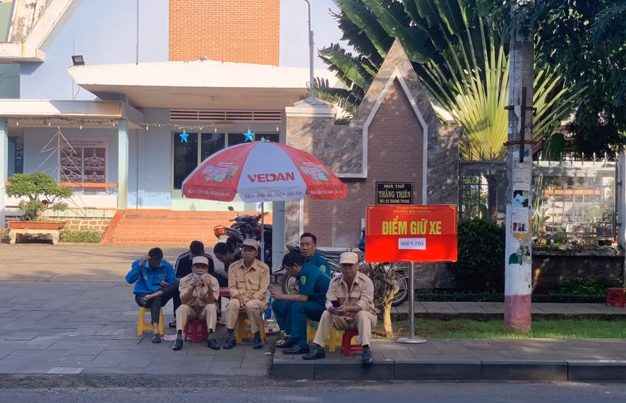 Lực lượng dân quân, trật tự tổ chức giữ xe miễn phí cho thí sinh và phụ huynh tại điểm thi trường THPT Lê Lợi (TP. Pleiku). Ảnh Hạ Vy