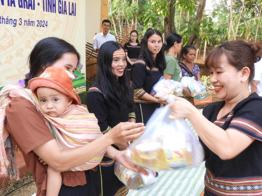 Phó Giám đốc Sở Thông tin và Truyền thông Lê Thị Thu Hương (bìa phải) trao quà các hộ nghèo và gia đình có hoàn cảnh khó khăn của làng Dun De, xã Ia Bă. Ảnh Thanh Nhật