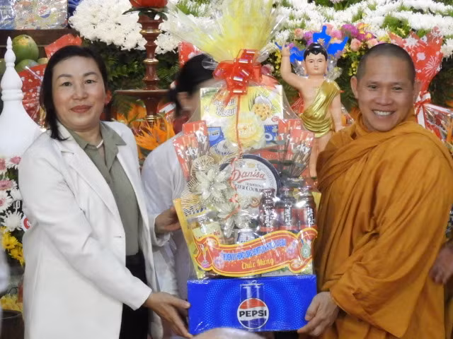 Phó Bí thư Thường trực Huyện ủy, Chủ tịch HĐND huyện Nguyễn Thị Lành (trái) tặng lẵng quà chúc mừng Đại Lễ Phật đản. Ảnh Thanh Nhật