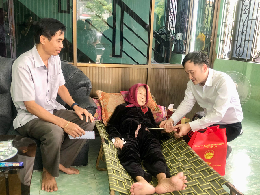 Đồng chí Nguyễn Tuấn Anh-Ủy viên Ban Thường vụ Tỉnh ủy, Phó Chủ tịch UBND (bìa phải) tặng quà cho gia đình bà Huỳnh Thị Bốn (tổ dân phố 7, thị trấn Phú Túc) là thân nhân liệt sĩ. Ảnh: Lê Nam