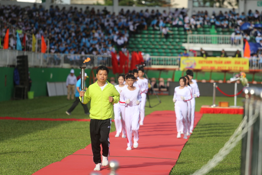 Phó Chủ tịch UBND tỉnh Nguyễn Hữu Quế nhận đuốc từ các VĐV tiêu biểu để thắp sáng đài đuốc truyền thống của Hội khỏe. Ảnh: Văn Ngọc