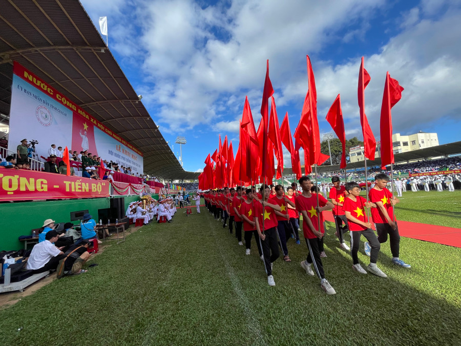 Các học sinh diễu hành khối hồng kỳ tại Lễ khai mạc. Ảnh: Văn Ngọc