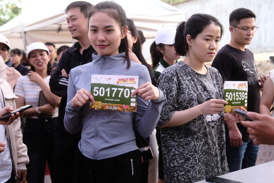 Các VĐV được hỗ trợ nhiệt tình trong việc nhận bib. Ảnh: Bi Ly