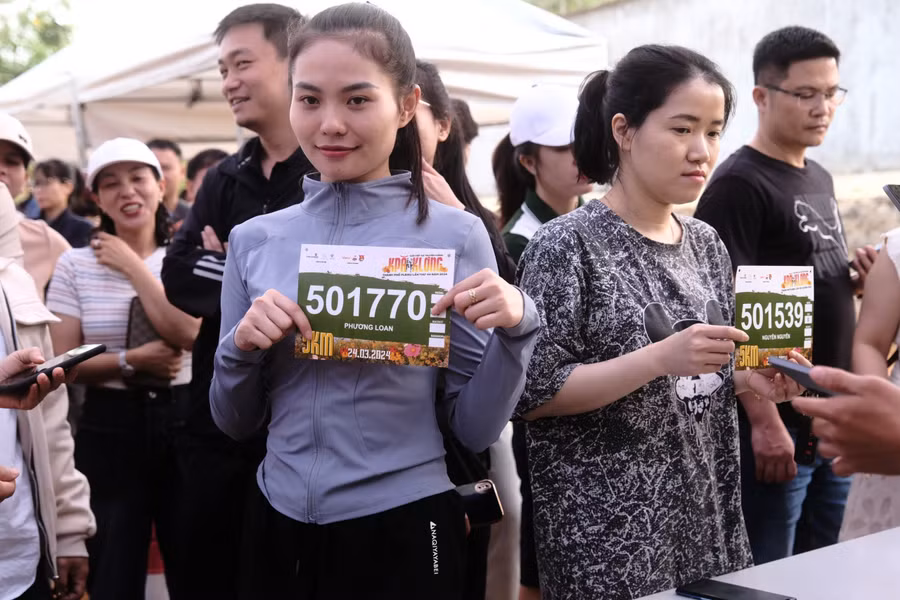 Các VĐV được hỗ trợ nhiệt tình trong việc nhận bib. Ảnh: Bi Ly