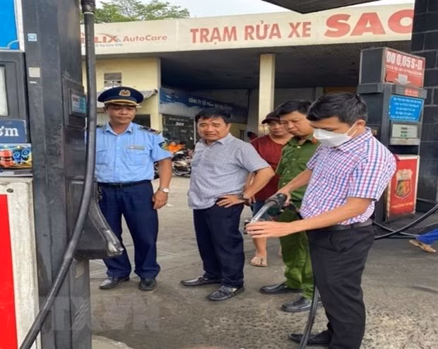 Đoàn kiểm tra lấy mẫu xăng của doanh nghiệp kiểm tra và test nhanh. (Ảnh: TTXVN)