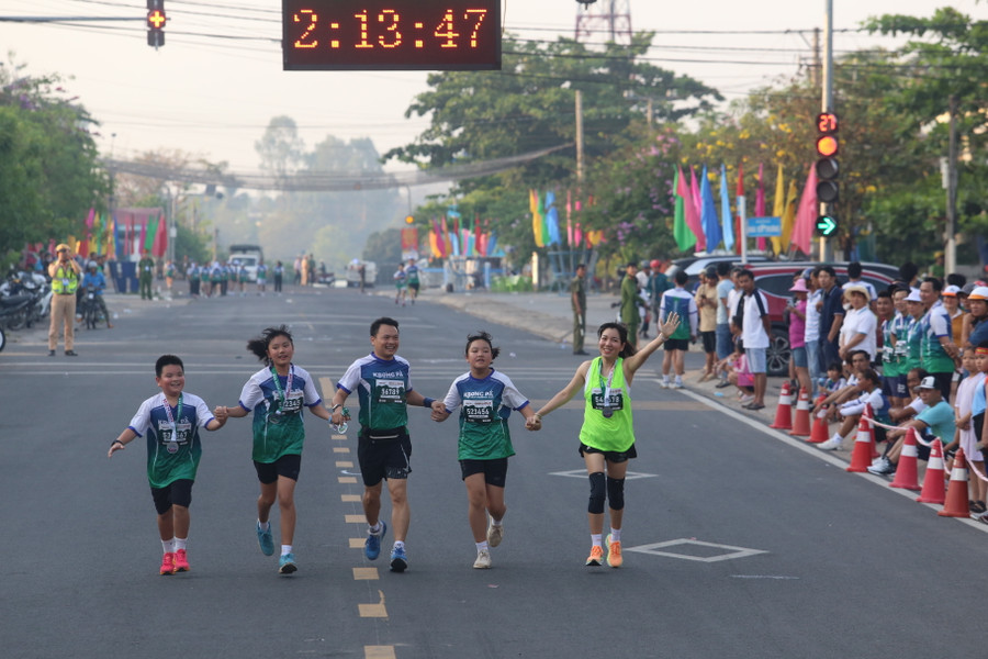 Cả gia đình hào hứng dắt tay nhau về đích. Ảnh: Văn Ngọc Cả gia đình hào hứng dắt tay nhau về đích. Ảnh: Văn Ngọc