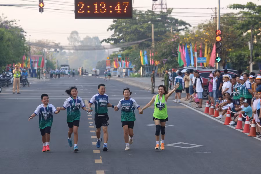 Cả gia đình hào hứng dắt tay nhau về đích. Ảnh: Văn Ngọc