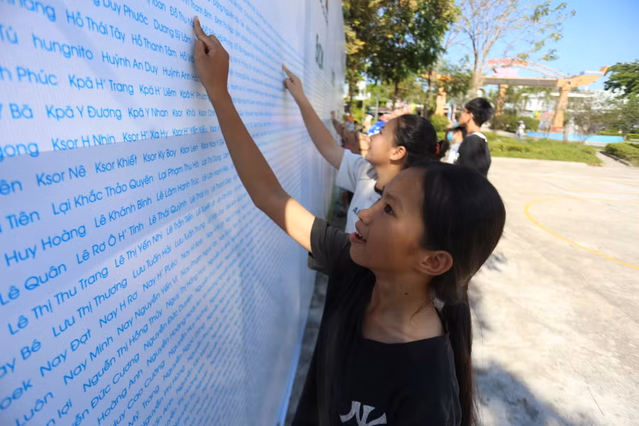 Các VĐV hào hứng tìm tên mình trên bảng ghi danh. Ảnh: Văn Ngọc