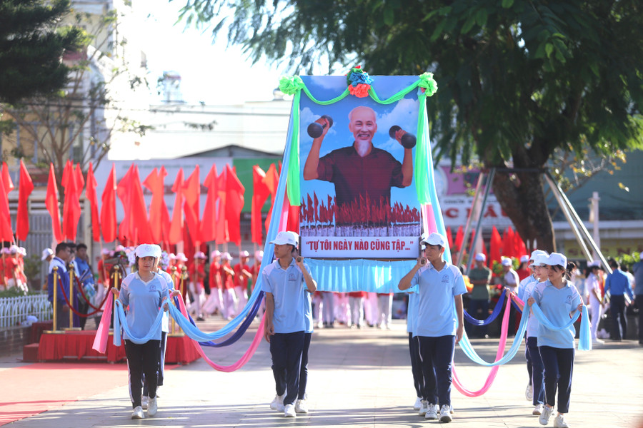 Các em học sinh rước ảnh Bác Hồ trong phần diễu hành lễ khai mạc. Ảnh: Văn Ngọc