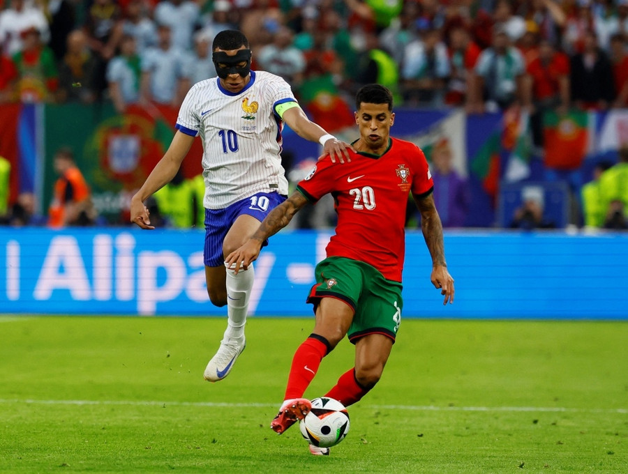 Mbappe (trái) bị các hậu vệ đối phương kèm cặp kỹ càng. Ảnh: UEFA