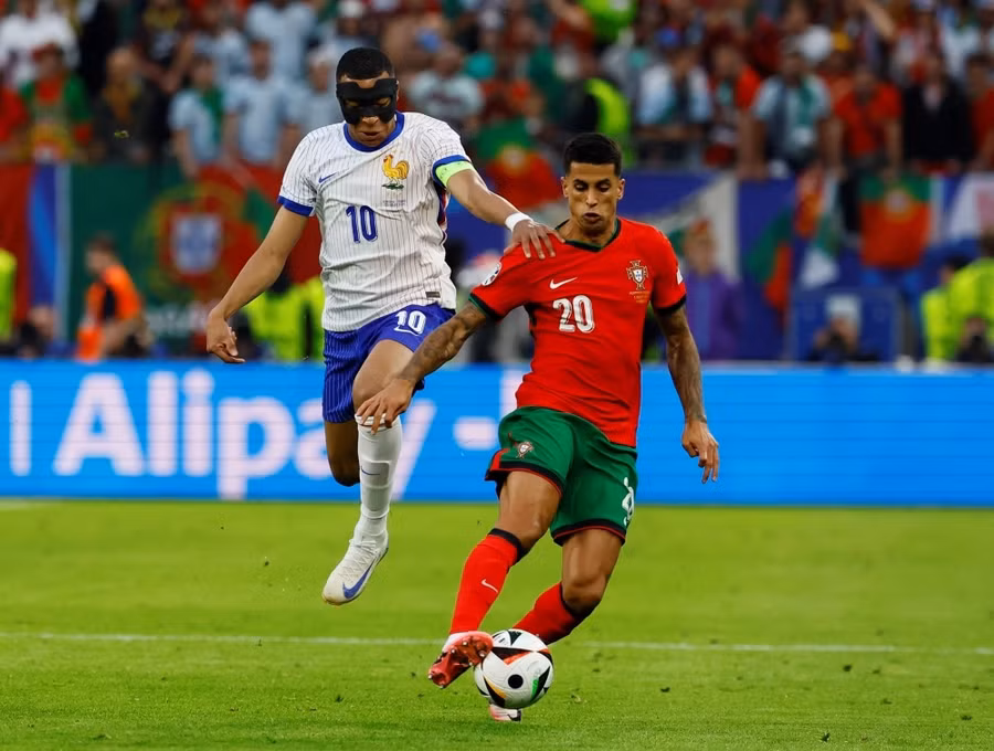 Mbappe (trái) bị các hậu vệ đối phương kèm cặp kỹ càng. Ảnh: UEFA