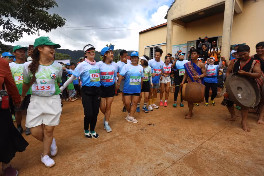 Các VĐV thích thú khi được giao lưu với đội cồng chiêng của làng Pờ Yầu. Ảnh: Văn Ngọc