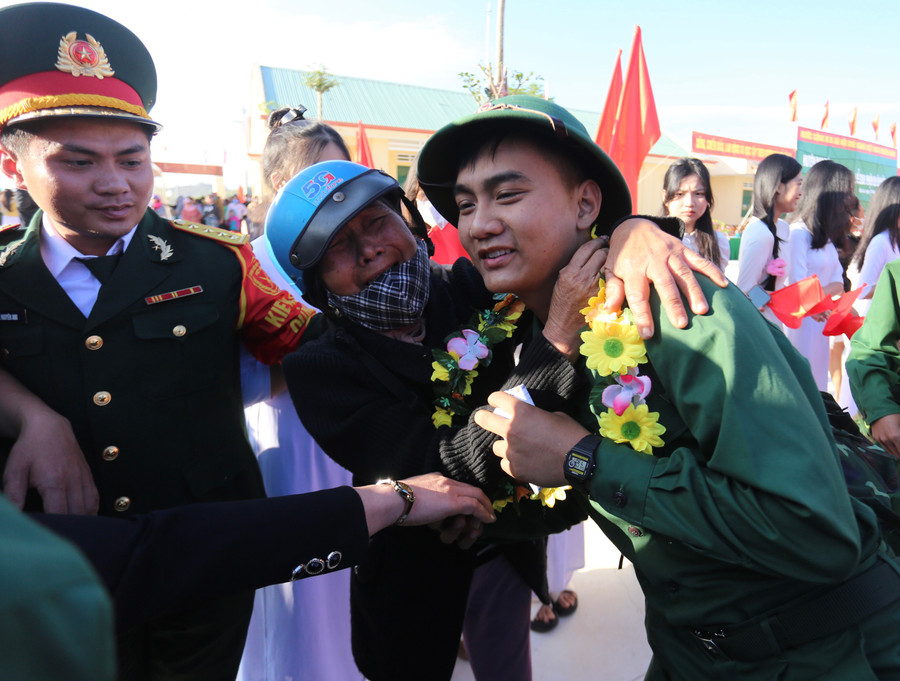 Một người mẹ đã không kìm được xúc động, tự hào khi thấy con trai khoác lên mình màu áo lính, tự tin lên đường nhập ngũ. Ảnh: Văn Ngọc