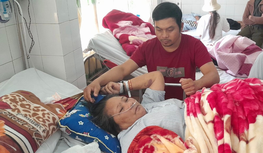 Anh Tuấn đang chăm sóc bà Mừng tại Khoa Ung bướu của Bệnh viện Đa khoa tỉnh. Ảnh: Văn Ngọc