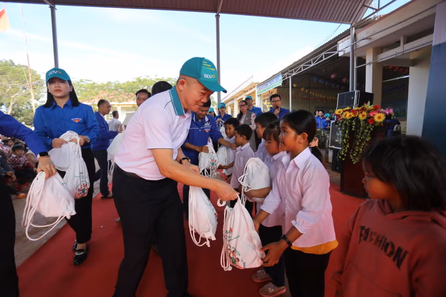 Các đại biểu trao quà cho các em học sinh nhân dịp Tết đến Xuân về. Ảnh: Văn Ngọc