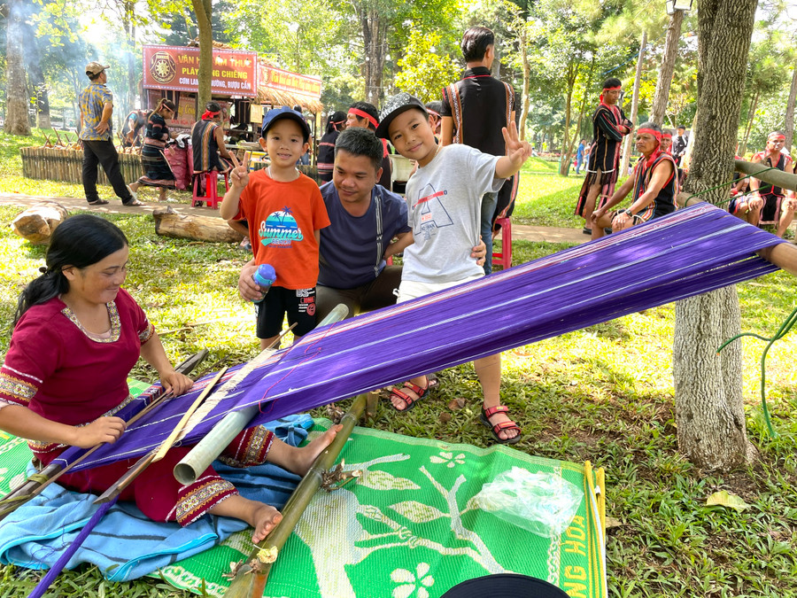 Một phụ huynh đưa con đến tìm hiểu về nghề dệt thổ cẩm tại Ngày hội. Ảnh: Lam Nguyên Một phụ huynh đưa con đến tìm hiểu về nghề dệt thổ cẩm tại Ngày hội. Ảnh: Lam Nguyên