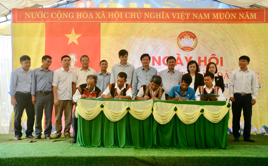 Đại diện các hộ gia đình, thôn trưởng, Trưởng ban Công tác Mặt trận làng Kret Krot cùng ký kết hưởng ứng thi đua. Ảnh: Lam Nguyên