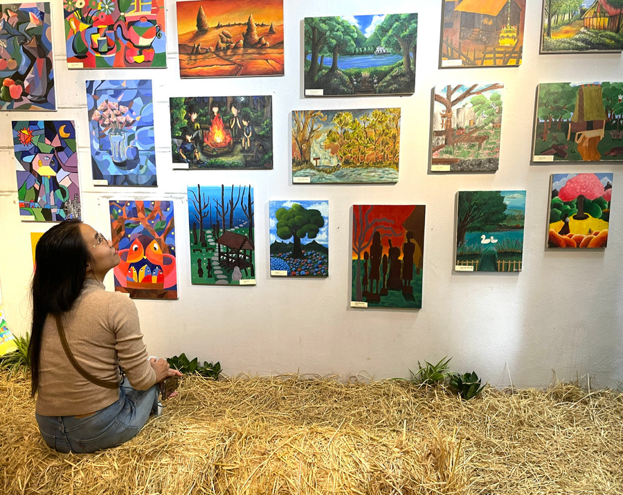 Chị Hồ Thị Lan Nhi say sưa với không gian tràn ngập sắc màu tại triển lãm. Ảnh: Lam Nguyên