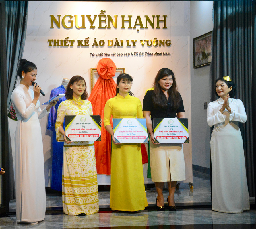 Nhà thiết kế Nguyễn Hạnh (bìa phải) đại diện CLB Áo dài Sống Xanh Pleiku trao tặng 30 bộ áo dài nữ sinh cho 3 đơn vị. Ảnh: Lam Nguyên.