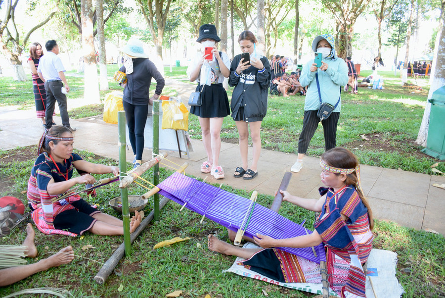 Du khách thích thú trước phần trình diễn dệt thổ cẩm của các nghệ nhân tại Ngày hội Văn hóa các dân tộc tỉnh Gia Lai lần thứ 1-năm 2022. Ảnh: Lam Nguyên