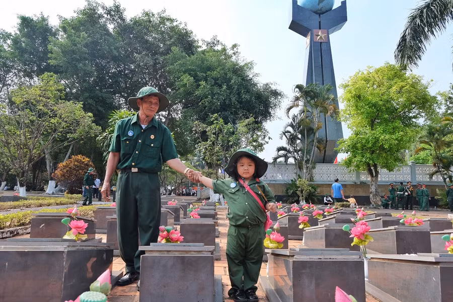 Cựu chiến binh Võ Công Hiệp (Phú Yên) đưa cháu nội Võ Trần Thanh Nhã đến thắp hương cho đồng đội. Ảnh: Hoàng Ngọc