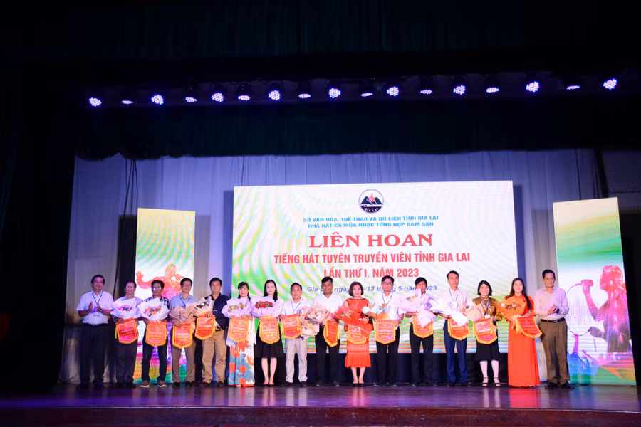 Phó Giám đốc Sở Văn hóa-Thể thao và Du lịch Nguyễn Đức Hoàng (bìa phải) trao hoa và cờ lưu niệm cho các đơn vị. Ảnh: Lam Nguyên