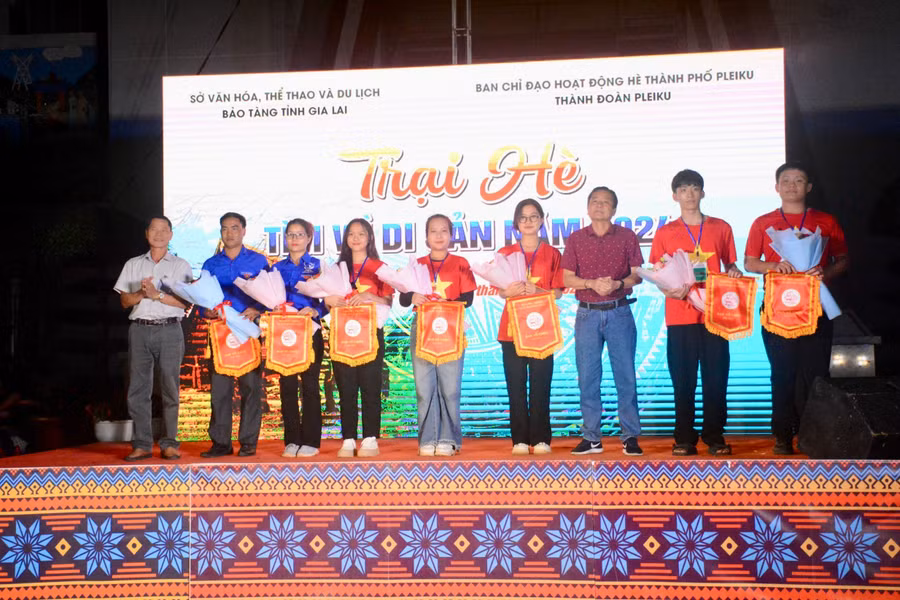 Ban tổ chức tặng hoa, cờ lưu niệm cho đại diện 7 tiểu trại tham gia trại hè "Tìm về di sản". Ảnh: Lam Nguyên