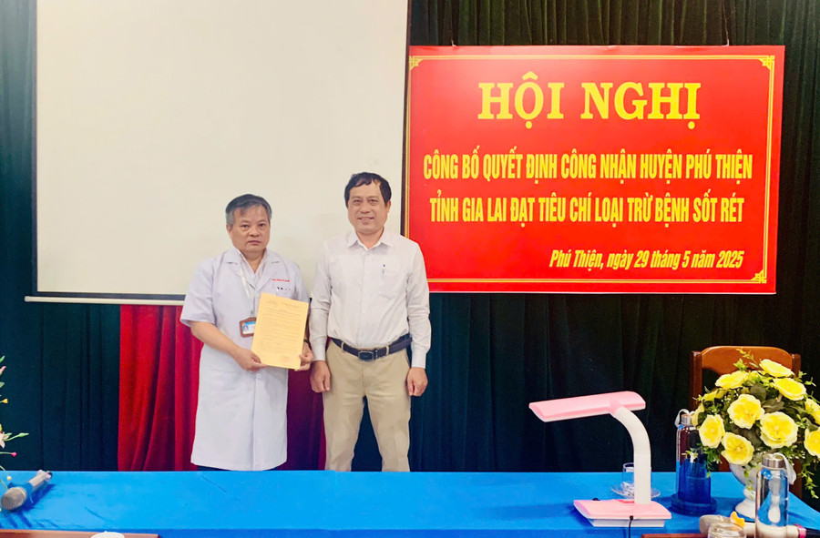 Ông Bá Tường Đăng Phong (bên phải)-Phó Giám đốc Trung tâm Kiểm soát bệnh tật tỉnh đã trao quyết định công nhận huyện Phú Thiện đạt tiêu chí loại trừ bệnh sốt rét cho đại diện lãnh đạo đơn vị. Ảnh: Hồng Quý z6651057689216-84d21faab8d2f4e4637ccbe8026bcdaa.jpg