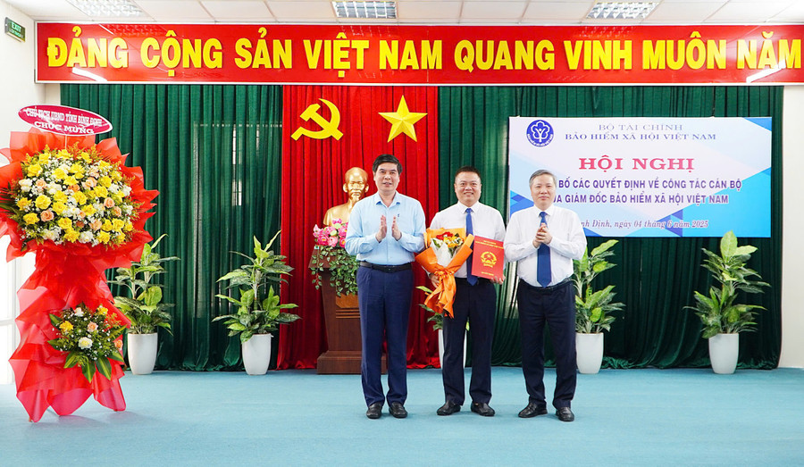 Phó Giám đốc BHXH Việt Nam Nguyễn Đức Hòa (bên phải) và Phó Chủ tịch UBND tỉnh Bình Định Lâm Hải Giang trao Quyết định bổ nhiệm và tặng hoa cho Giám đốc BHXH khu vực XXIII Vũ Mạnh Chữ. Ảnh: ĐVCC z6671806913211-8279ab029d3c3bd75c6a00f028ee8a9a.jpg