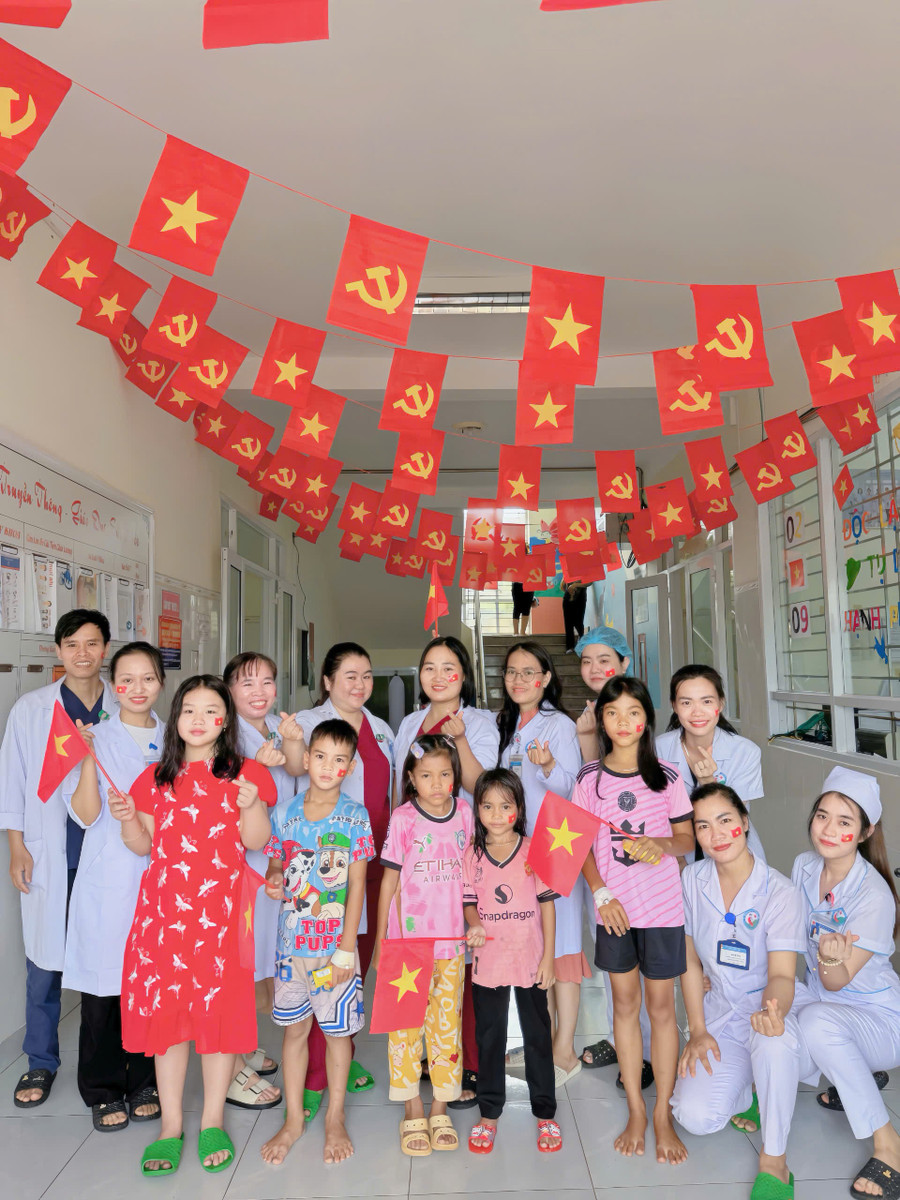 Y-bác sĩ, bệnh nhi và người nhà bệnh nhi chụp ảnh tại góc trang trí của Khoa Bệnh nhiệt đới. Ảnh: CTV z6966515706721-6fa6feaa013d44498cd2c8c57d21d1ea.jpg