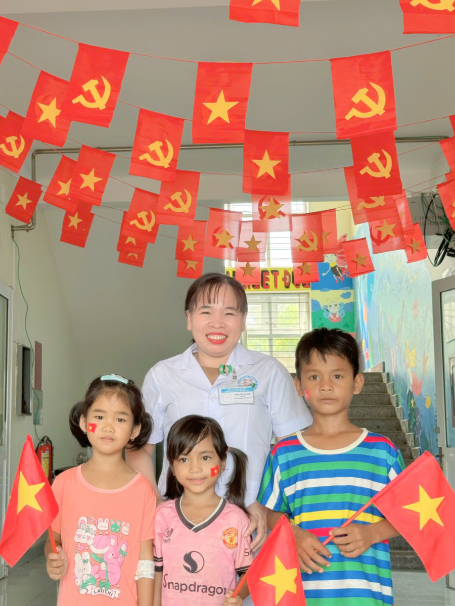Bác sĩ Nguyễn Thị Mới và bệnh nhi chụp ảnh tại góc trang trí của Khoa Bệnh nhiệt đới. Ảnh: CTV z6966515678589-6618c21643171e8adb0d4a6b737d3fbb.jpg