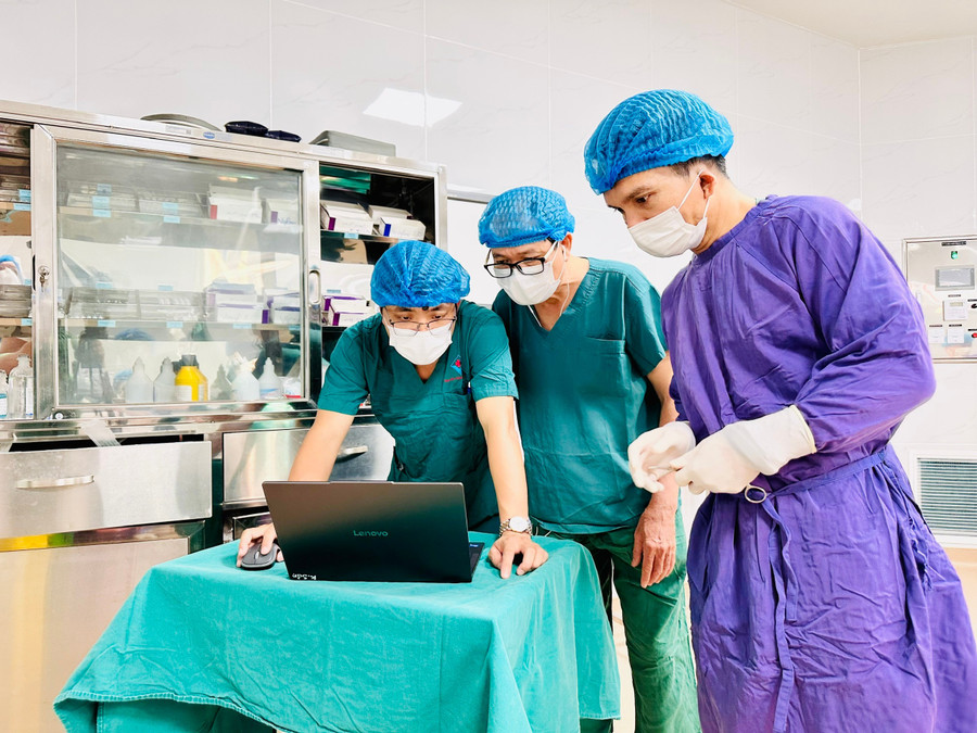 Tiến sĩ, bác sĩ Đoàn Tiến Mỹ (giữa) kiểm tra bệnh án lần cuối trước khi phẫu thuật cho bệnh nhân. Ảnh: Như Nguyện z7080520664953-662b65f25b787f273cfe4be73b6d28bc.jpg